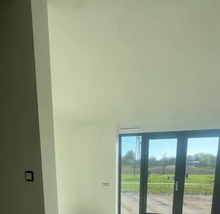 Kamer met behangklaar stucwerk en openslaande tuindeuren met uitzicht op het land