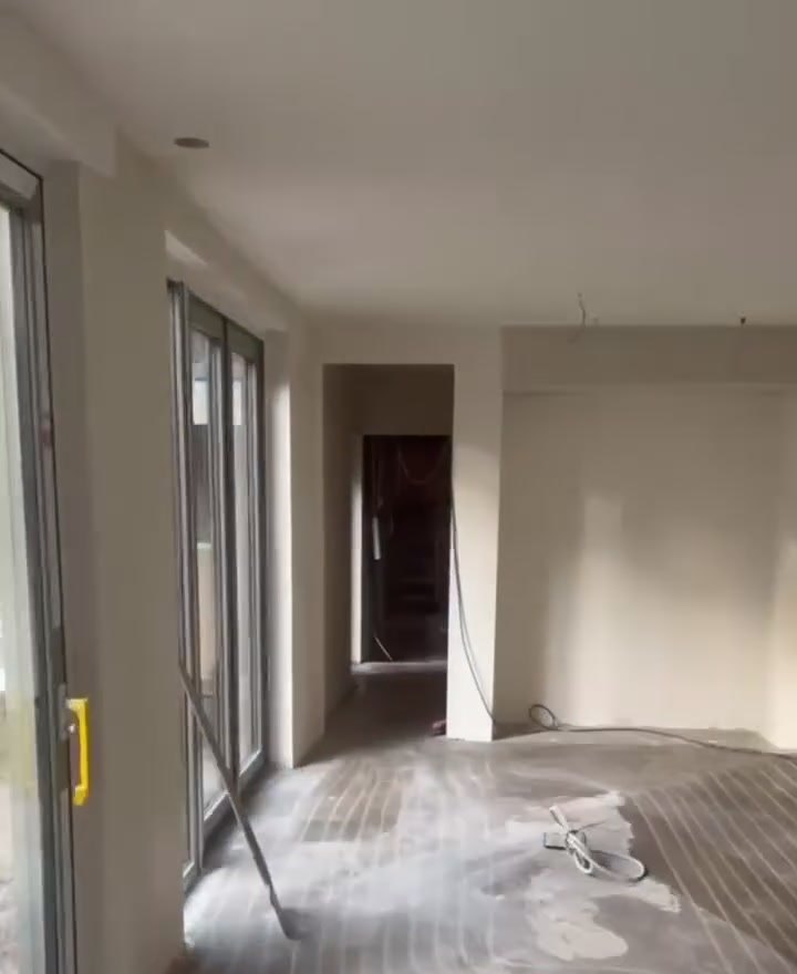 Woonkamer in Dalfsen met vers gestuukte wanden en grote schuifpui, de vloer nog in de ruwbouw