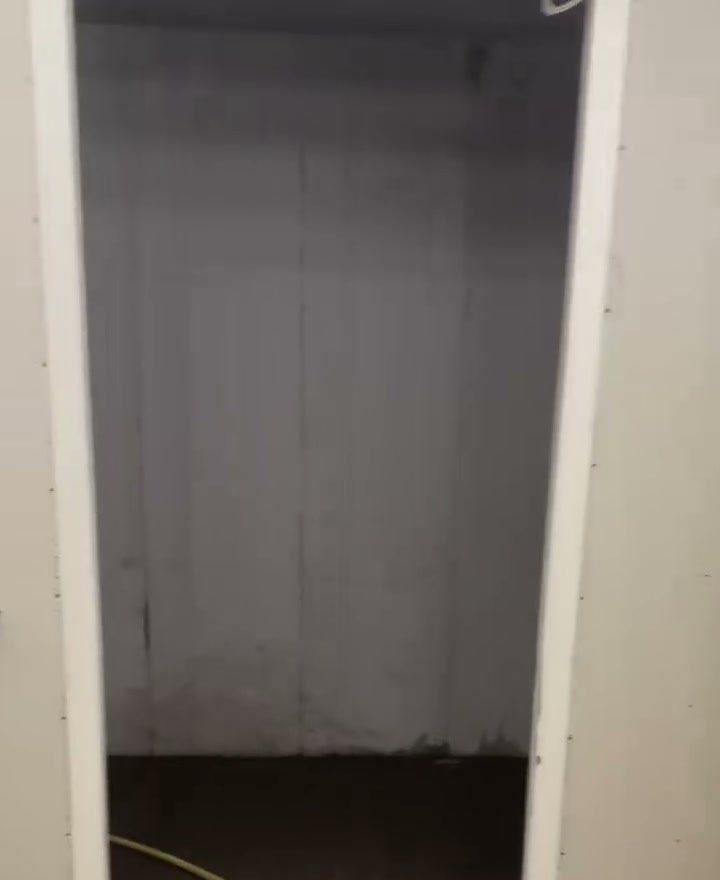 Gang in een nieuwbouwwoning met gestuukte wanden, nog zonder vloer en deuren